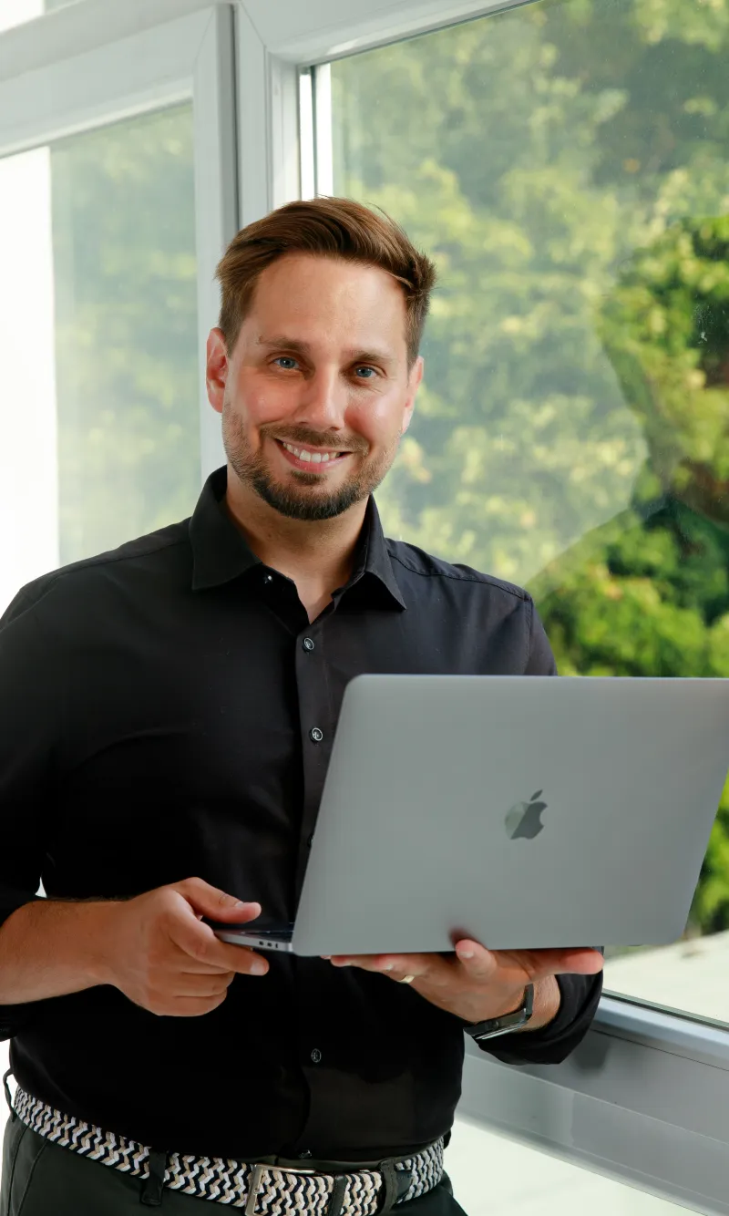 Daniel Herrmann mit Laptop am Fenster
